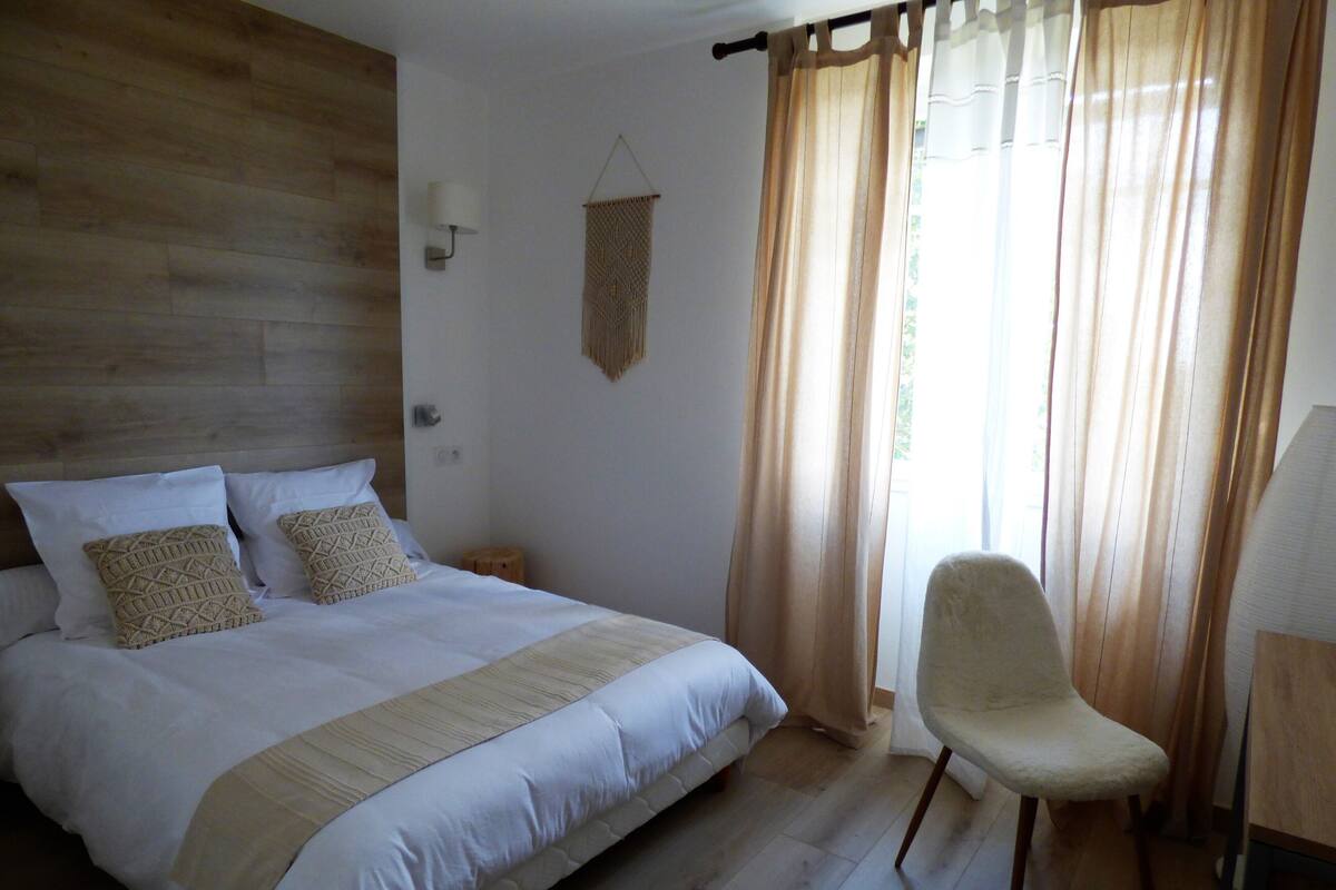 Une chambre à coucher avec un grand lit, une chaise et une tête de lit en bois.
