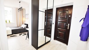 Une pièce avec un lit, un miroir et une porte.