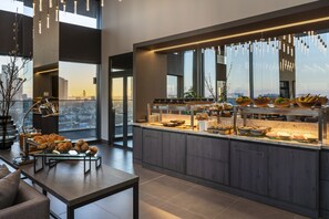Eine moderne Küche mit einer Frühstückstheke, großen Fenstern und Blick auf die Stadt.