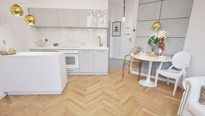 A modern kitchen with white cabinetry, a central island, and gold pendant lighting.