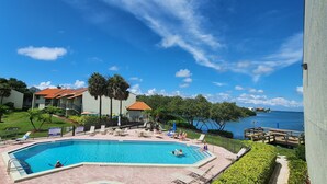 A swimming pool with lounge chairs and a view of the sea. - Lovely 1st Floor, 1 BR condo with garden, pool and water view in Tierra Verde (Tierra Verde)