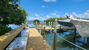 A wooden dock extending into calm waters with a boat docked on the right. - Lovely 1st Floor, 1 BR condo with garden, pool and water view in Tierra Verde (Tierra Verde)