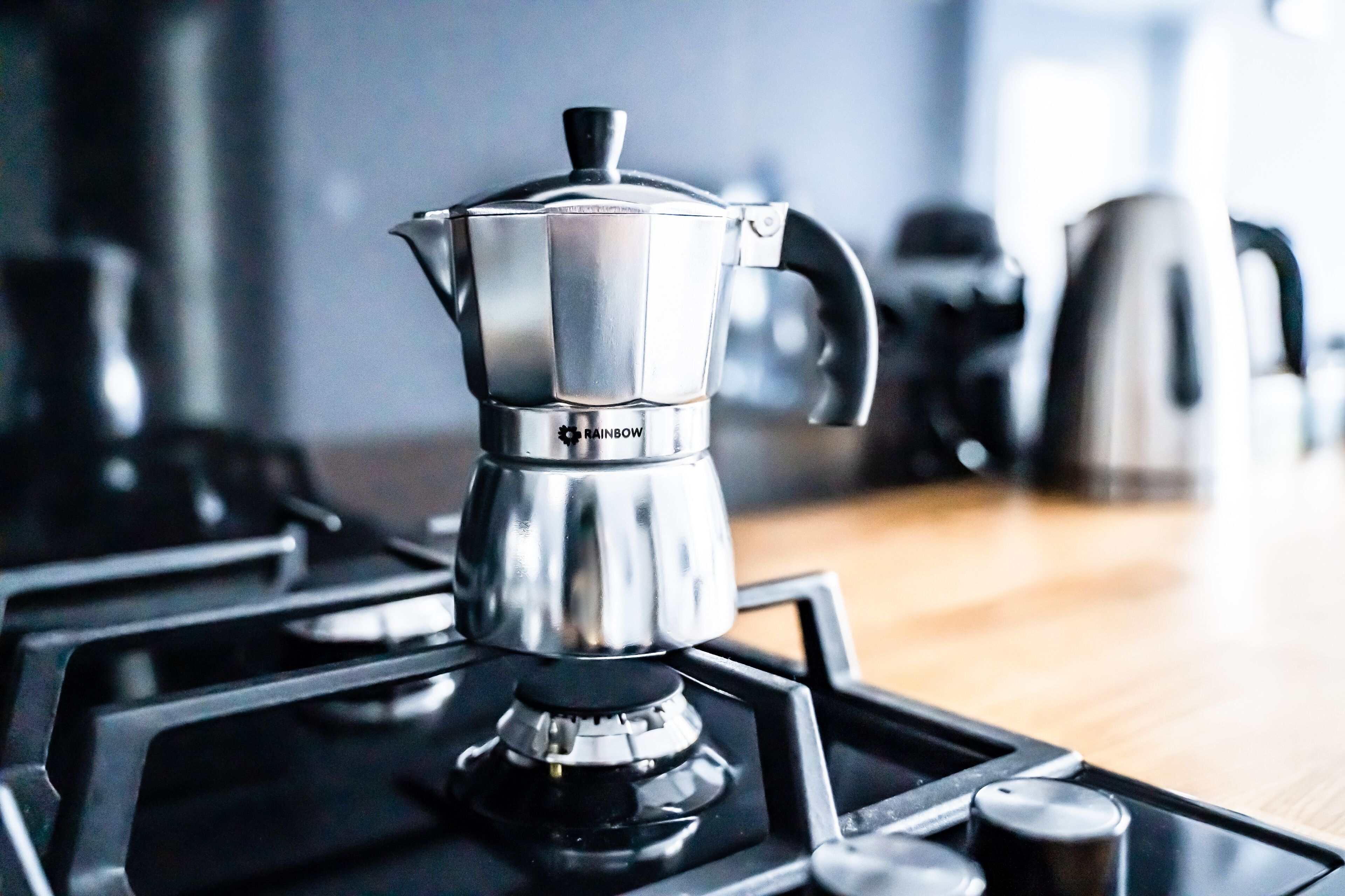 Een roestvrijstalen koffiezetapparaat op een draagbaar gasfornuis.