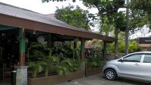 A covered outdoor area with a car parked nearby. - Nyiur Indah Beach Hotel (Pangandaran)