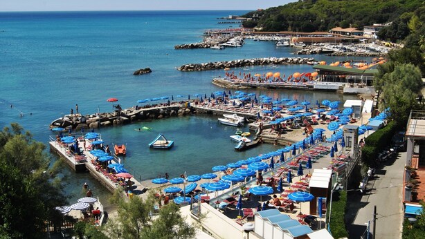 A coastal marina with boats, a pier, and a beach area with umbrellas. - Residenza Venus - Venus Grazioso bilocale -50 mt dal mare (Castiglioncello)