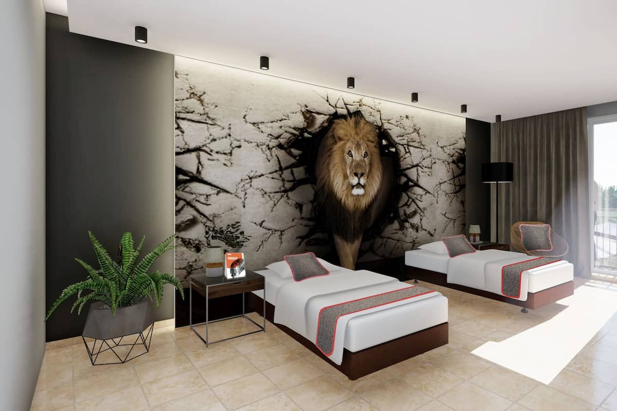 Habitación de hotel moderna con dos camas, un gran mural de un león, una planta en maceta y vistas a un balcón.