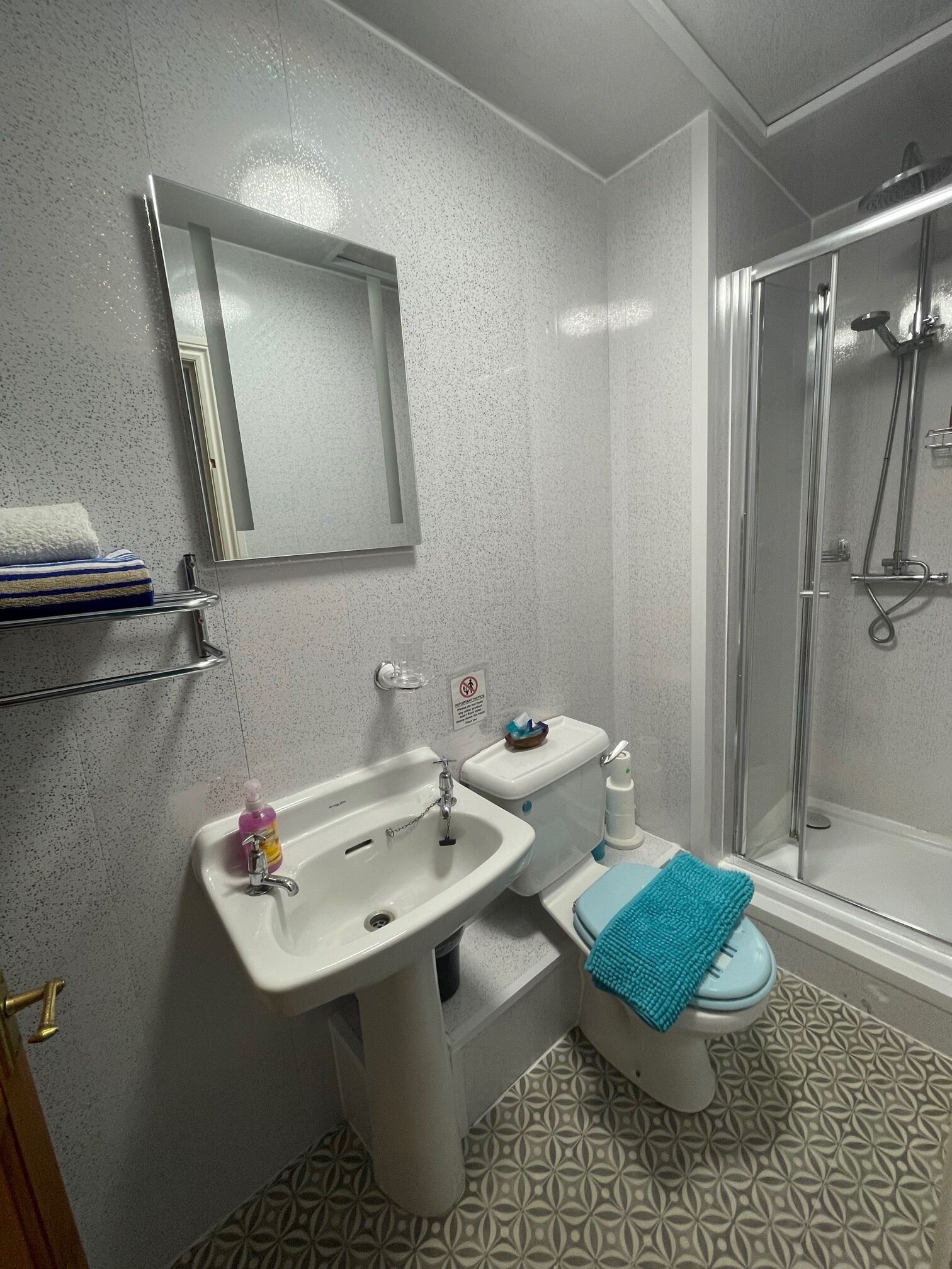 Un baño con lavamanos, inodoro y ducha.