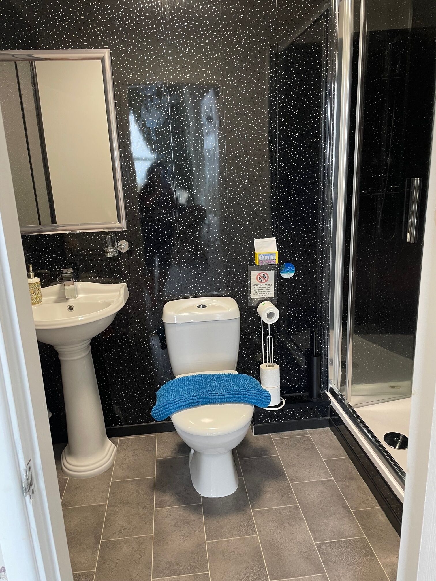 A bathroom with a toilet, sink, and shower.