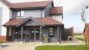 A modern building with a 'Welcome' sign, a covered entrance, and a signboard advertising breakfast. - The Churchill By Greene King Inns (Swindon)