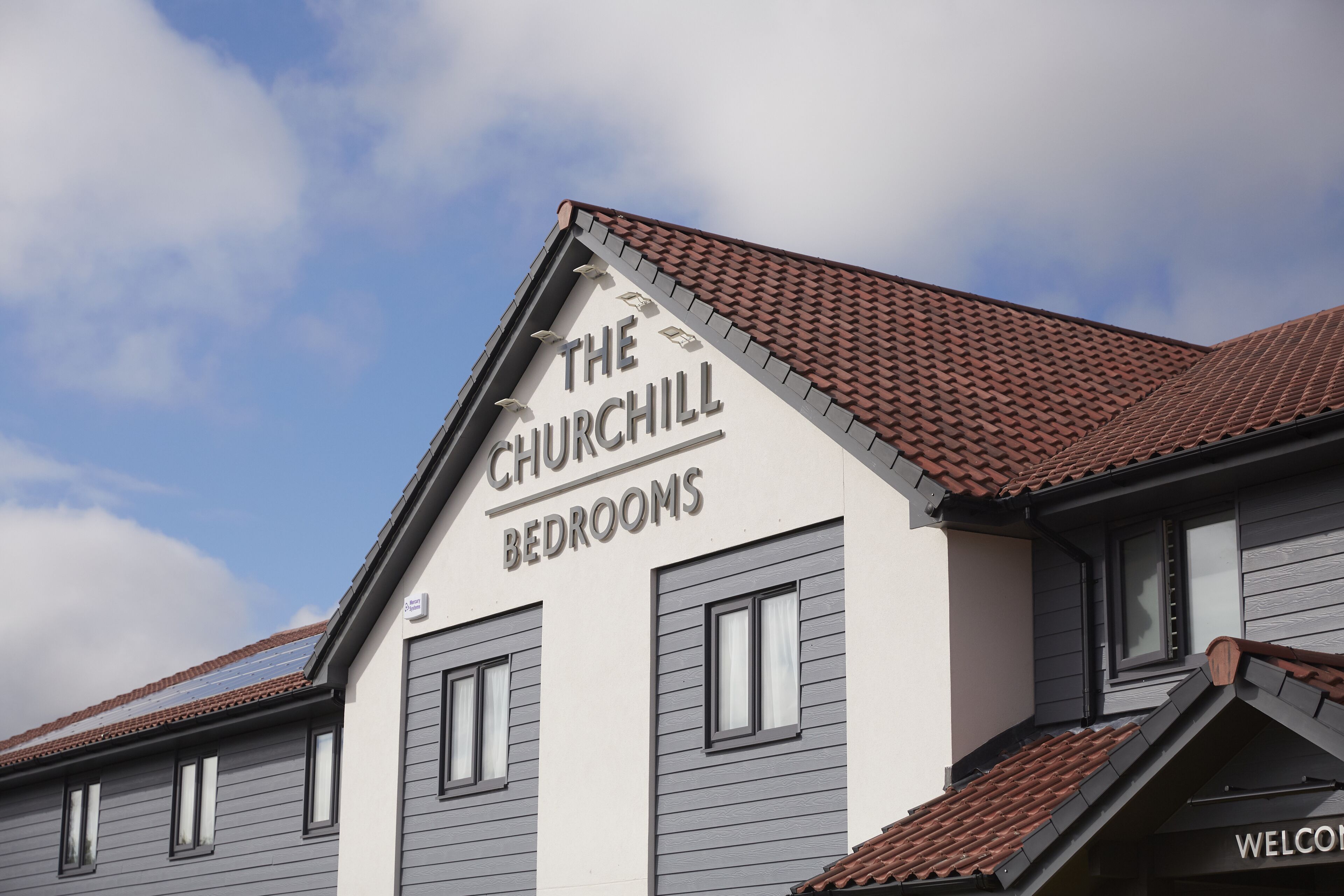 Un edificio con un letrero que dice "The Churchill Bedrooms".