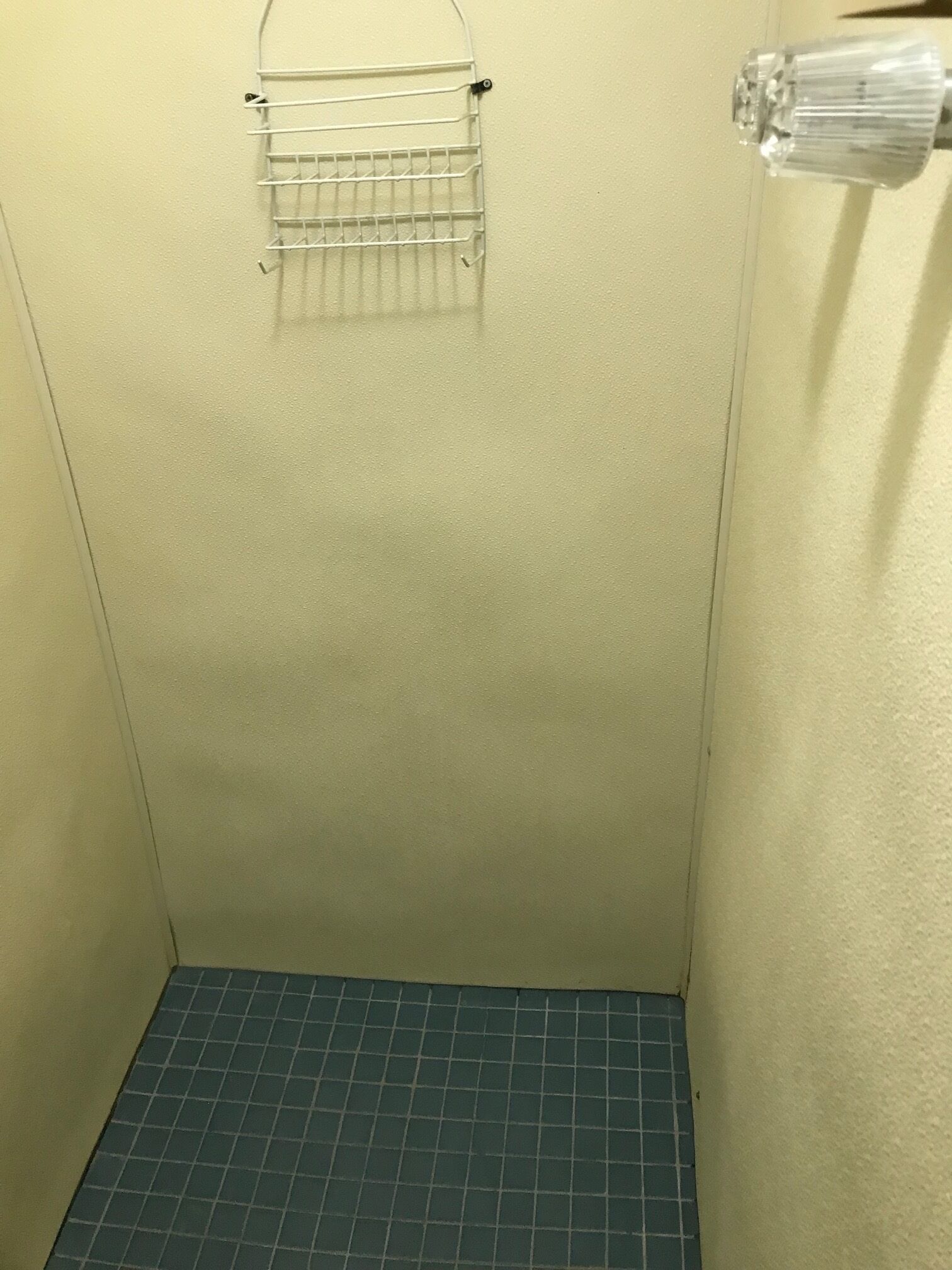 A small, tiled bathroom with a shower area.