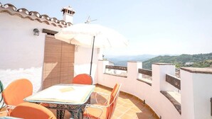 A terrace with a table and chairs, a white umbrella, and a view of the landscape. - La Solana, your corner in the Serranía de Ronda (Benadalid)