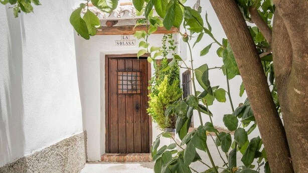 A narrow pathway leading to a wooden door with a sign above it reading "LA SOLANA." - La Solana, your corner in the Serranía de Ronda (Benadalid)