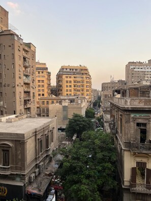 Un paysage urbain avec des immeubles à étages multiples, des rues étroites et des arbres bordant les trottoirs.