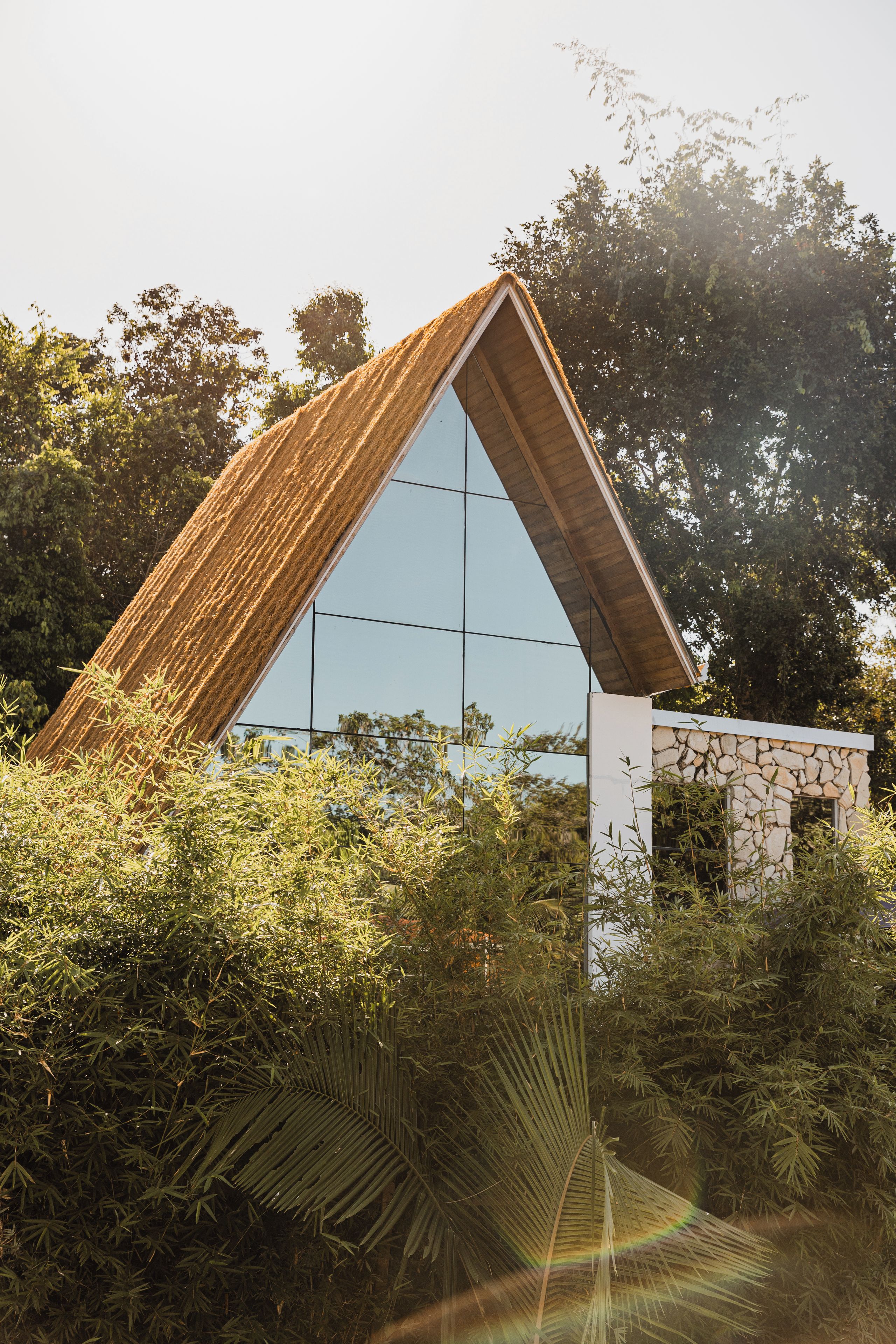 Un edificio moderno con techo triangular y amplia fachada de vidrio.