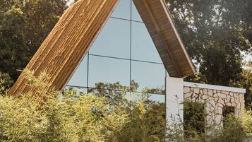 Un edificio moderno con techo triangular y amplia fachada de vidrio.