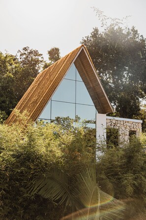 Un edificio moderno con techo triangular y amplia fachada de vidrio.