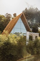 Un edificio moderno con techo triangular y amplia fachada de vidrio.