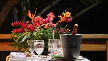 Una mesa con un arreglo floral, varios vasos y un balde.