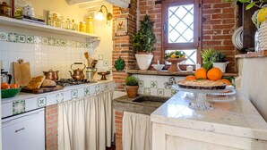 A kitchen with a brick wall, a window, and various kitchen items. - ROSYABATE COTTAGE with Private Garden and views between Lucca and Pistoia (Uzzano)