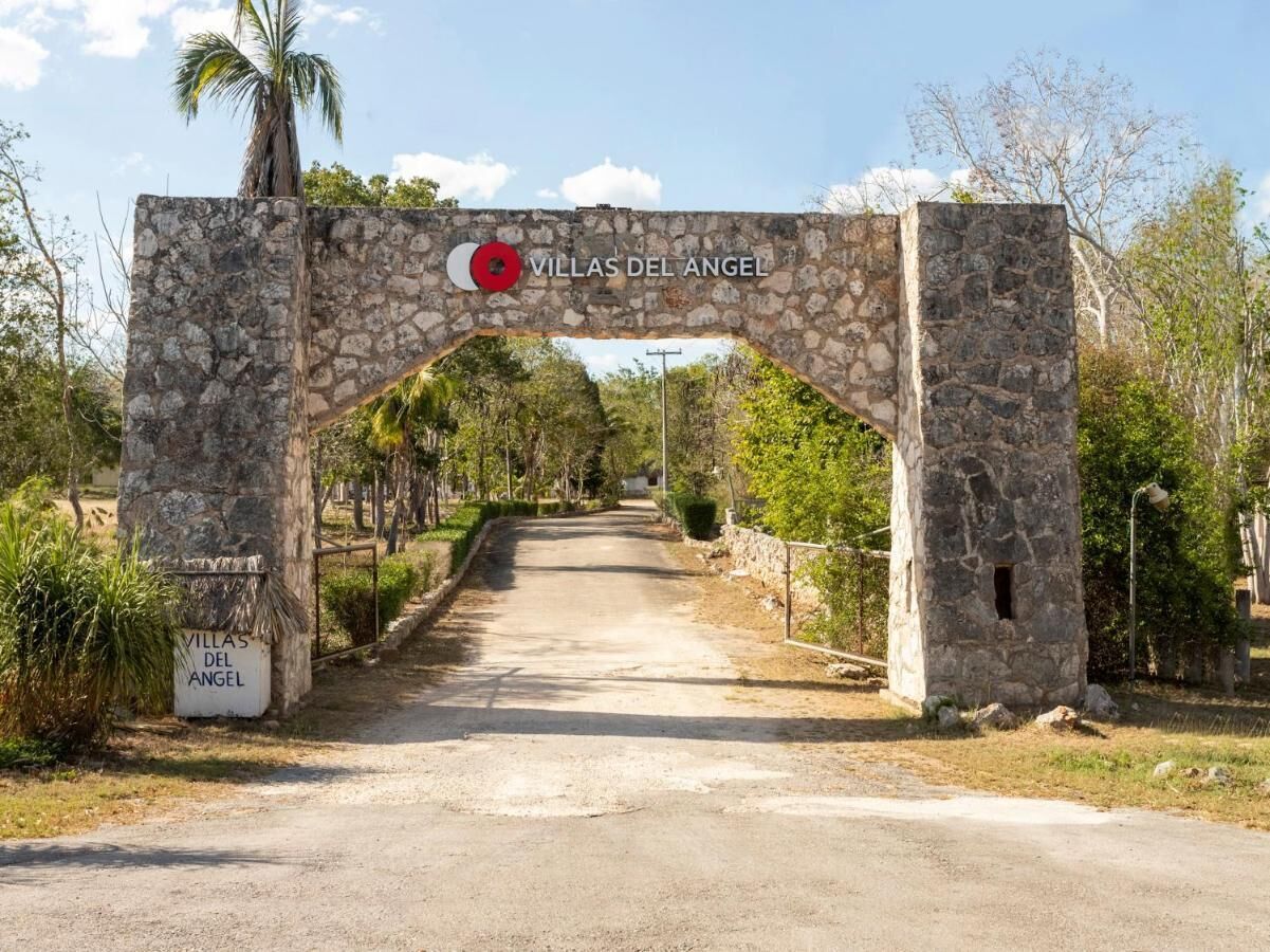 A stone archway with the sign 'Villas del Angel' indicating a property entrance.