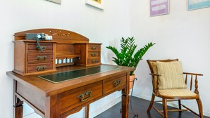 A wooden desk with drawers, a camera on top, and a potted plant beside a wooden chair. - Sunny Three Bedroom Loft in the Heart of Porto (Porto)