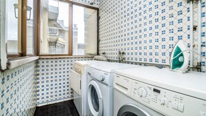 A laundry room with a washing machine, a dryer, and a window. - Sunny Three Bedroom Loft in the Heart of Porto (Porto)