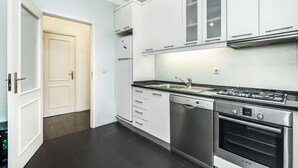 A modern kitchen with white cabinets, a Bosch dishwasher, a stove, and an oven. - Sunny Three Bedroom Loft in the Heart of Porto (Porto)