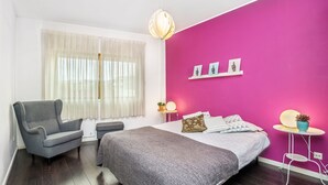 A bedroom with a bed, a chair, a bedside table, a lamp, and a wall with a shelf. - Sunny Three Bedroom Loft in the Heart of Porto (Porto)