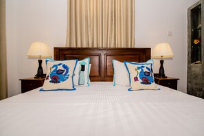 A hotel room with a large bed, two bedside tables with lamps, and a wooden headboard. - Ardeen Villa (Kahandamodara)