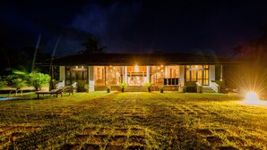 A well-lit house with a large front porch, a swimming pool, and a lawn. - Ardeen Villa (Kahandamodara)