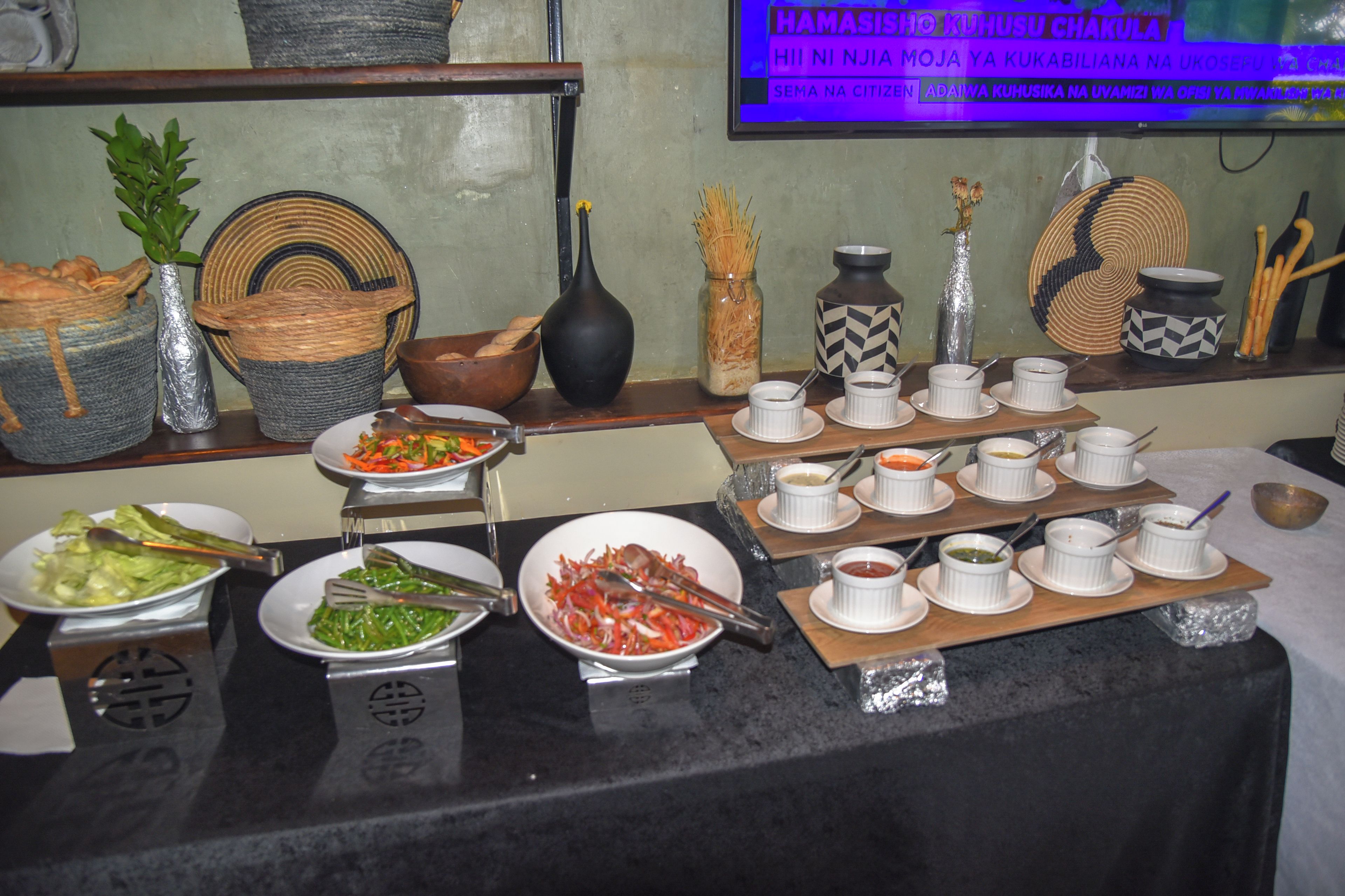 A buffet table with various dishes and condiments.