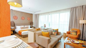 Ein Hotelzimmer mit Bett, Schlafsofa, Esstisch und einer kleinen Küchenzeile.