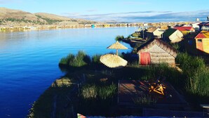 A riverside village with traditional houses and thatched roofs. - Uros Quechua Lodge (Puno)