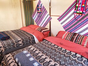 A room with two beds, each with patterned bedding and pillows. - Uros Quechua Lodge (Puno)