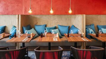 Un restaurante con mesas de madera y asientos acolchados azules.