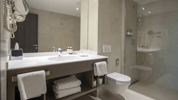 A modern bathroom with a large vanity, a toilet, and a shower area.