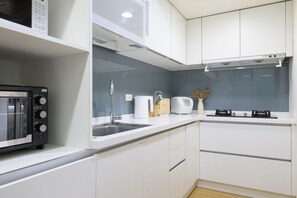 A modern kitchen with white cabinets, a microwave, a toaster, and a sink. - 4B4b Three Suites 1 Min to Blue Line MRT (Taipei)