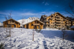 A wooden lodge with multiple balconies and a snow-covered landscape.