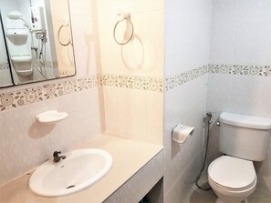 Un baño con lavabo, inodoro y espejo.