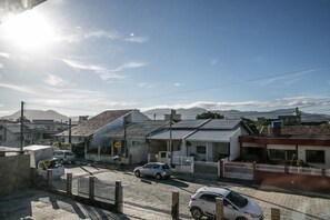 Una calle residencial con casas, coches y cielo despejado.