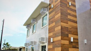 A modern building with a wooden facade and multiple air conditioning units.