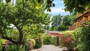 A garden pathway leading to a building with a tiled roof and a yellow umbrella. - Grand F3 - Apartment for 4 to 6 people (Figanières)