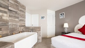 Ein modernes Badezimmer mit einer großen Badewanne, einem Spiegel und einer Toilette.