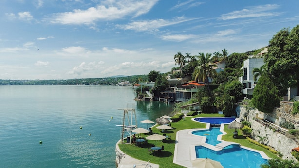 Ein Resort mit Schwimmbad, Sitzgelegenheiten im Freien und Seeblick.