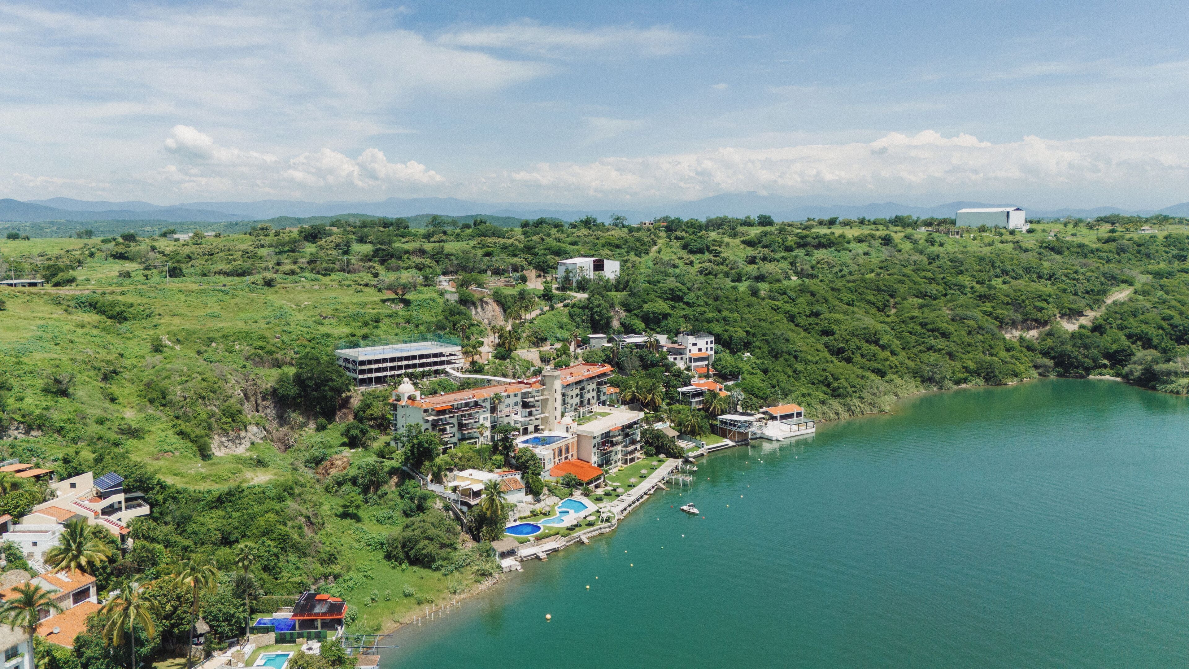 A coastal resort with multiple buildings, a swimming pool, and a marina.