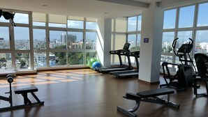 A gym with treadmills, exercise balls, and weight equipment. - Rooftop Pool with Ocean and City Views (Santo Domingo)