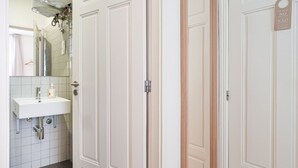 Ein Badezimmer mit einem weißen Waschbecken, einem Spiegel und einem Handtuch an der Wand.