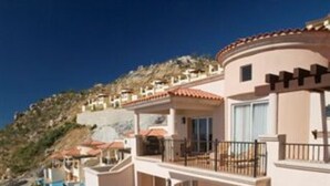 Un resort moderno con piscina, mobiliario exterior y vistas del paisaje circundante.