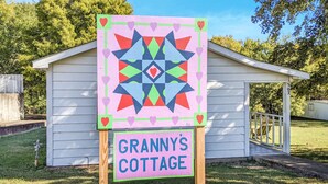 Schild für Granny's Cottage mit einem farbenfrohen Quiltdesign und einer Namensschild.